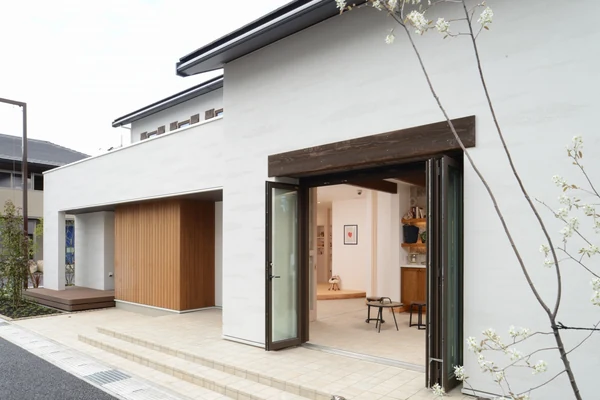 大きな折戸を全開にした住まいの外観。屋内と屋外がつながる開口