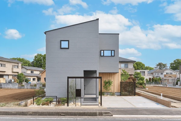 アルネットホームの注文住宅の外観。白い外壁に木の格子を組み合わせた2階建て