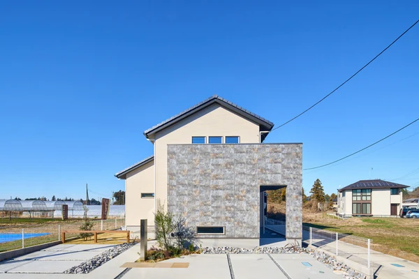 アルネットホームの注文住宅の外観。石張りの壁面と白い外壁を組み合わせた住まい